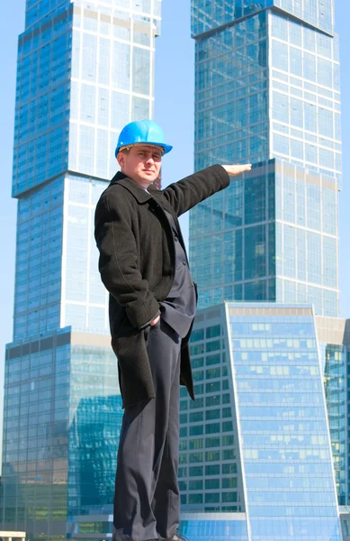 Engineer with blue hard hat near skyscrapers — Stock Photo, Image