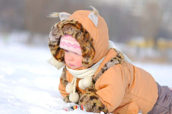 Счастливая маленькая девочка играет в снегу — стоковое фото
