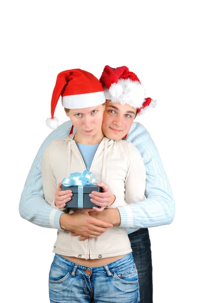 Pareja joven con sombreros de Santa Claus sosteniendo cajas de regalo aisladas sobre fondo blanco — Foto de Stock