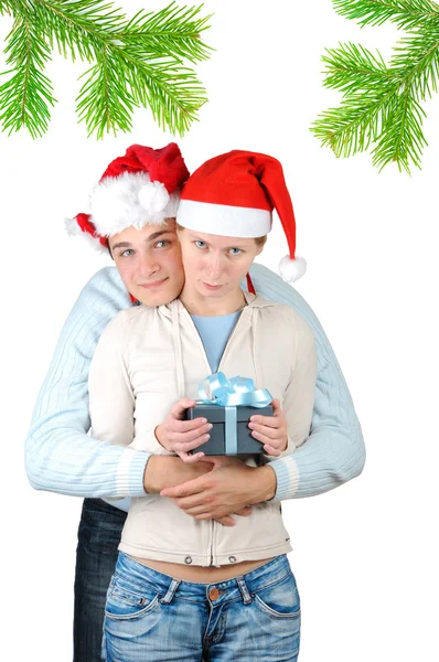 Pareja joven con sombreros de Santa Claus sosteniendo cajas de regalo aisladas sobre fondo blanco — Foto de Stock