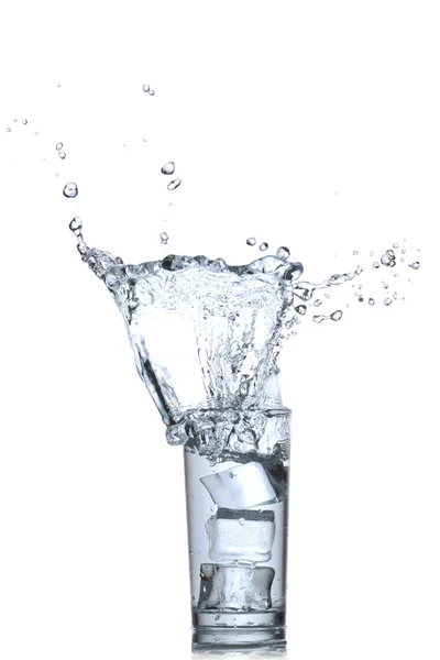 Вода бризкає в склянці на білому тлі — стокове фото