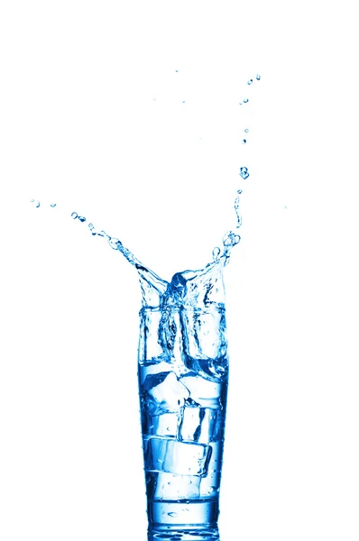 Spruzzi d'acqua nel bicchiere su sfondo bianco — Foto Stock