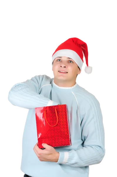 Jonge man in KERSTMUTS bedrijf aanwezig zak geïsoleerd op witte achtergrond — Stockfoto