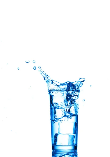 Spruzzi d'acqua nel bicchiere su sfondo bianco — Foto Stock