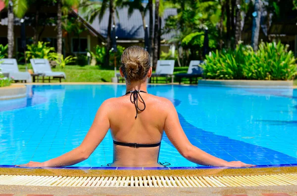 Woman relaxing in outdoor swimming pool — Stock Photo, Image