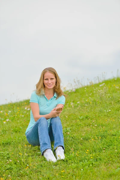 Young woman sitting on the grass Royalty Free Stock Photos