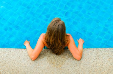 Yüzme havuzunda rahatlatıcı kadın. Arkadan Görünüm