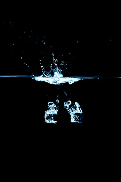 Cube de glace dans l'eau sur fond noir — Photo