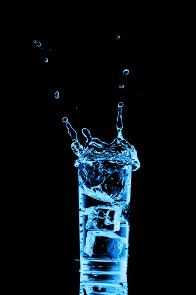 Glas vatten med isbitar på svart bakgrund — Stockfoto