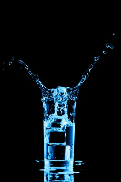 Glas water met ijsblokjes op zwarte ondergrond — Stockfoto