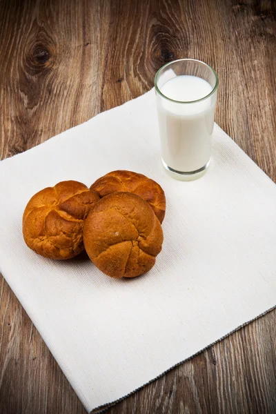 Brood en een glas melk op de houten tafel — Stockfoto