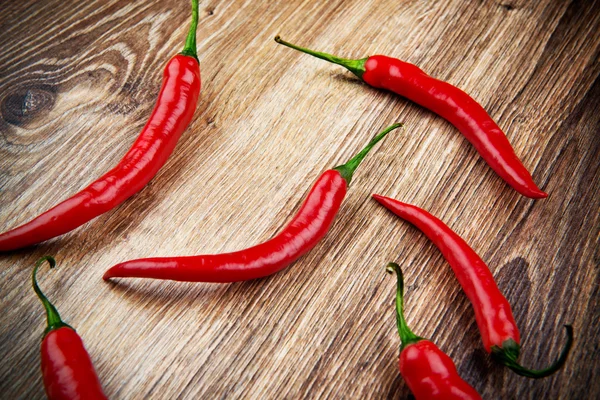 Organic chili peppers on wooden background — Stock Photo, Image