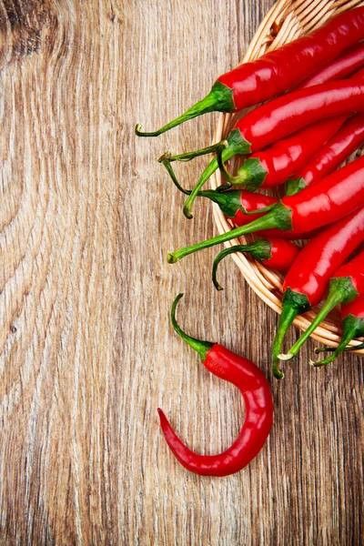 Organic chili peppers on wooden background — Stock Photo, Image