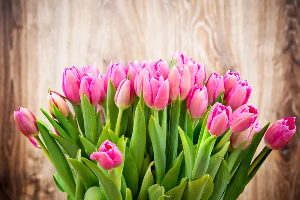 Kytice tulipánů na dřevěném pozadí — Stock fotografie