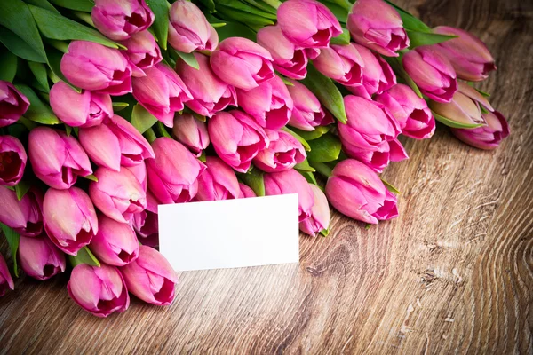 Buquê de tulipas e um cartão de saudação — Fotografia de Stock