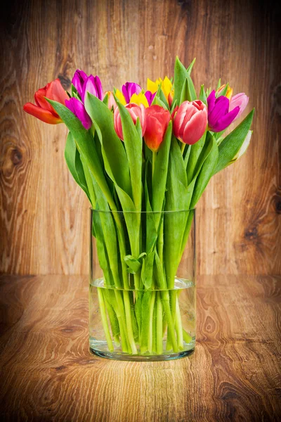 Тюльпаны в вазе на деревянном фоне — стоковое фото