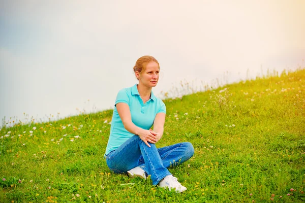 Vrouw zit op het gras — Stockfoto