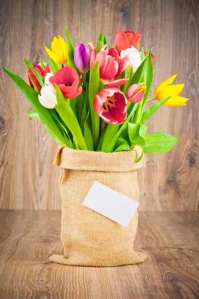 Tulipes dans le sac sur fond en bois — Photo