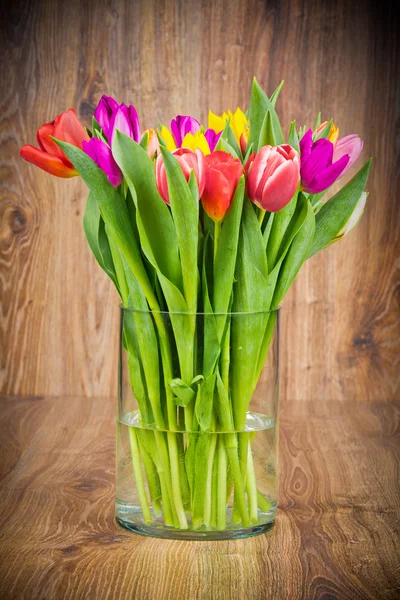 Tulipes dans le vase sur fond en bois — Photo