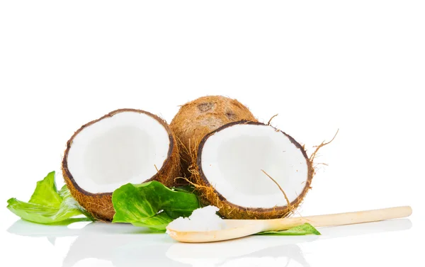 Kokosnöt med gröna blad och träsked — Stockfoto