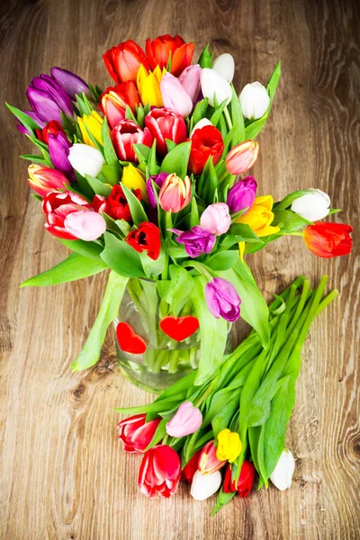 Tulips in the vase on wooden background — Stock Photo, Image