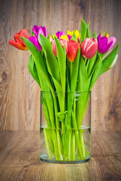 Tulpen in der Vase auf Holzgrund — Stockfoto