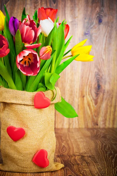 Tulipes dans le sac sur fond en bois — Photo
