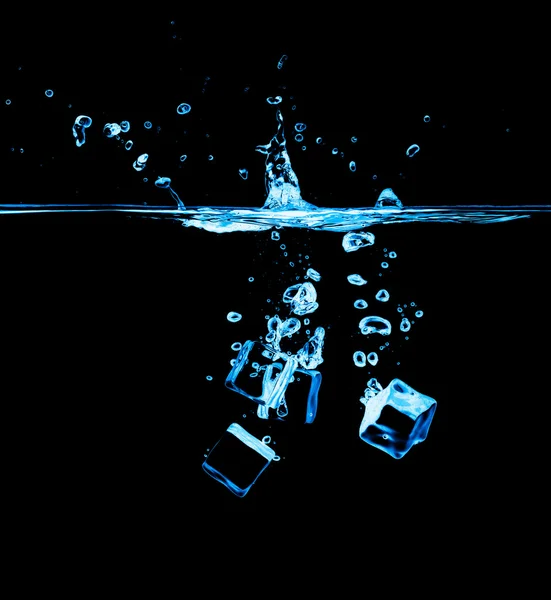 Кубики льоду у воді на чорному тлі — стокове фото