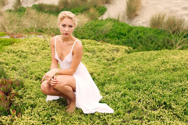 içinde beyaz çimlerde oturan kadın