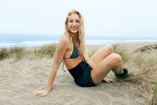 Smiling woman on shorts in sand — Stock Photo, Image