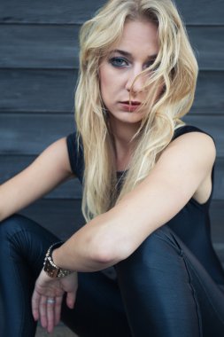 ahşap duvara yakın oturan sarışın kadın