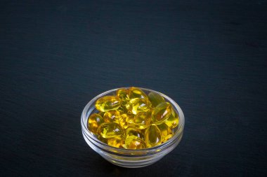Arka planda kopyalanmış omega 3 kapsüllü kase, düz konum