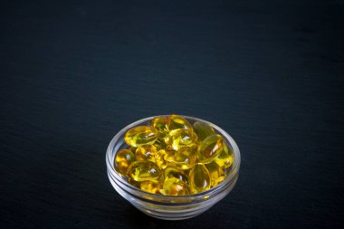 Arka planda kopyalanmış omega 3 kapsüllü kase, düz konum