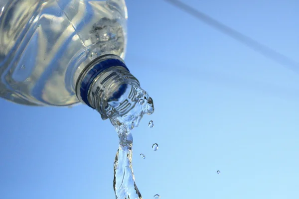 Wasser verschüttet aus Flasche lizenzfreie Stockbilder