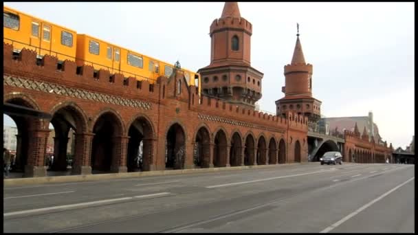 Oberbaumbridge po drugiej stronie rzeki Szprewy w Berlinie, zbudowany w 1894 roku, pociąg miejski przechodzi. — Wideo stockowe