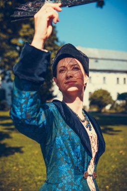 Mavi tarihi Barok kıyafetleri giymiş bir kadın portresi. Eski moda saç stili, açık havada. Lüks ortaçağ elbisesi