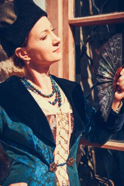 Mavi tarihi Barok kıyafetleri giymiş bir kadın portresi. Eski moda saç stili, açık havada. Lüks ortaçağ elbisesi