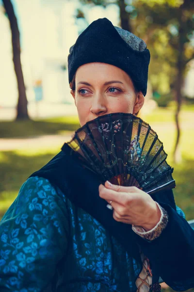 Mavi tarihi Barok kıyafetleri giymiş bir kadın portresi. Eski moda saç stili, açık havada. Lüks ortaçağ elbisesi