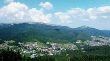Gökyüzü manzaralı, gökdelenli turistik bir yer, Ukrayna 'nın Bukovel Karpatlar şehrinde güneşli bir yaz günü. Doğal dış seyahat geçmişi.