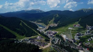 Gökyüzü manzaralı, gökdelenli turistik bir yer, Ukrayna 'nın Bukovel Karpatlar şehrinde güneşli bir yaz günü. Doğal dış seyahat geçmişi.