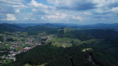 Gökyüzü manzaralı, gökdelenli turistik bir yer, Ukrayna 'nın Bukovel Karpatlar şehrinde güneşli bir yaz günü. Doğal dış seyahat geçmişi.