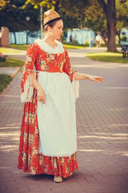 Esmer kadın portresi. Kırmızı tarihi Barok kıyafetler giymiş. Eski moda saç stili, açık havada. Orta sınıf ortaçağ elbisesi