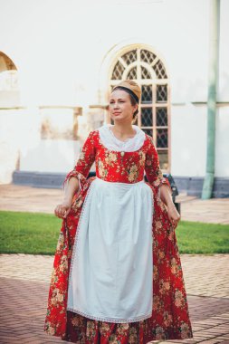 Esmer kadın portresi. Kırmızı tarihi Barok kıyafetler giymiş. Eski moda saç stili, açık havada. Orta sınıf ortaçağ elbisesi