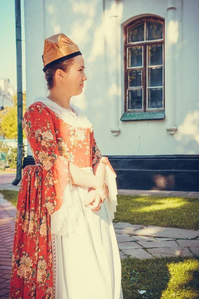 Esmer kadın portresi. Kırmızı tarihi Barok kıyafetler giymiş. Eski moda saç stili, açık havada. Orta sınıf ortaçağ elbisesi