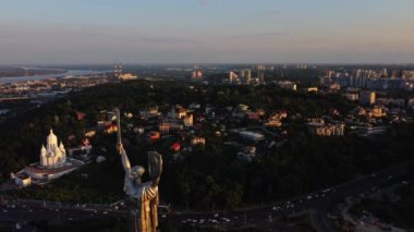 Kiev, Ukrayna, Haziran 2021 - Dinyeper Nehri kıyısında bulunan şanlı Anavatan Anıtı 'nın hava manzarası, gündüz ve akşam gün batımı. Ukrayna 'nın başkentinin ünlü eğlenceleri..