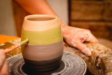 Potter çömlekçi çarkı üzerinde çalışıyor. Çömlek atölyesinde seramik sofra takımı yapma süreci. El işi ve sanat konsepti.