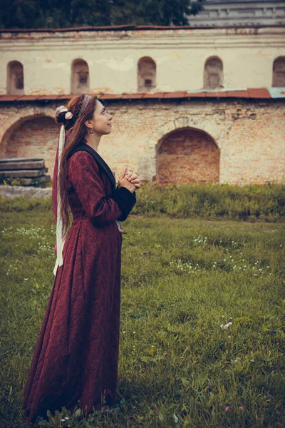 歴史的なバロック様式の服を着て 屋外で祈っているブルネットの女性の肖像画 中流階級の中世のドレス — ストック写真