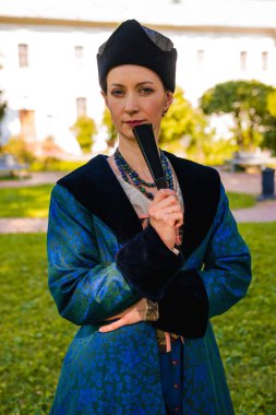 Mavi tarihi Barok kıyafetleri giymiş bir kadın portresi. Eski moda saç stili, açık havada. Lüks ortaçağ elbisesi