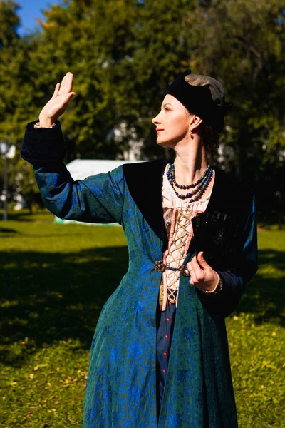 Portrait of woman dressed in blue historical Baroque clothes with old fashion hairstyle, outdoors. Luxurious medieval dress