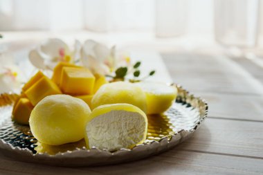 Ahşap arka planda mango meyveli Mochi tatlısı, yakın plan. Geleneksel Japon pirinç keki